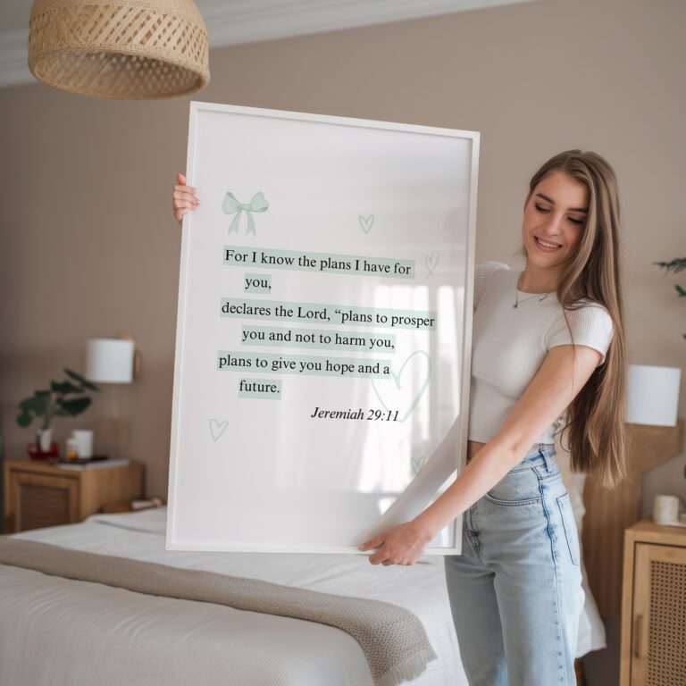 Woman holding framed Jeremiah 29:11 quote in a bedroom.