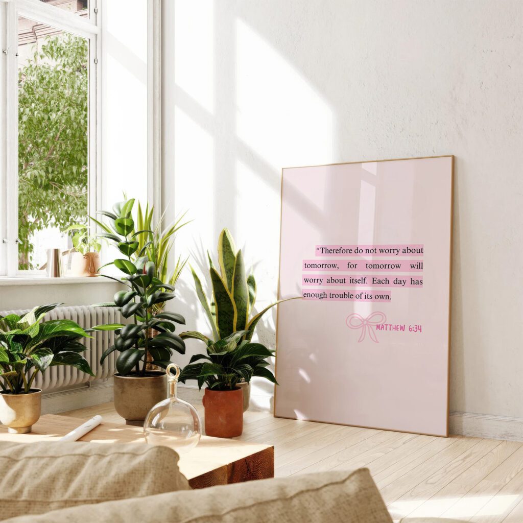 Bright room with plants and a framed motivational quote leaning against the wall.