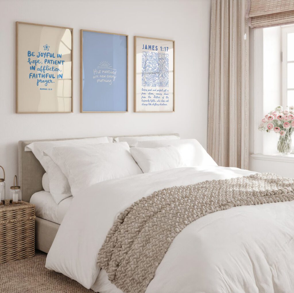 Cozy bedroom with a bed covered in white linens, wall art, and a window with flowers in a vase.